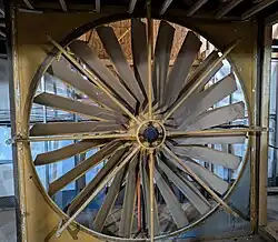 A large fan stands from floor to ceiling.