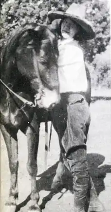 Portrait of Billie Maxwell posed with a horse