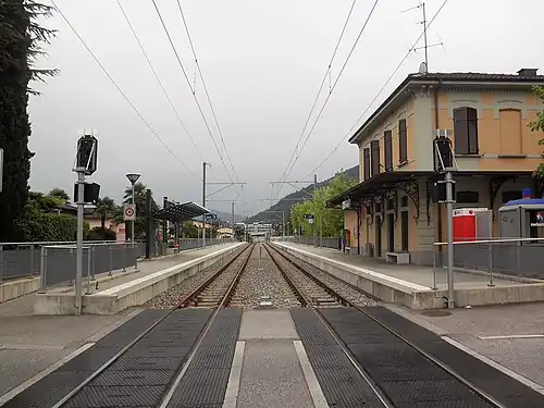 Two-story building with hip roof next to double-track railway line