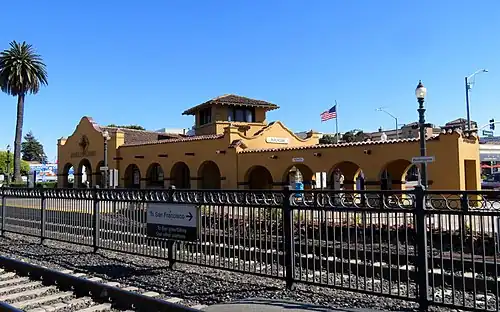 A yellow Mission-style railroad station building