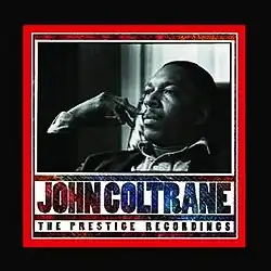 A black and white photo of a thirtysomething African-American man daydreaming. The box title design is in shades of red and blue with the words "JOHN COLTRANE. THE PRESTIGE RECORDINGS" and the cover has a narrow red border rounded by a wider black border.