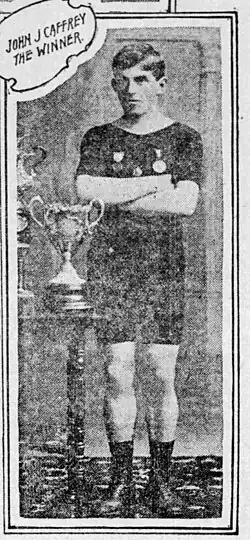 Black and white newspaper photograph of Caffrey standing with a trophy