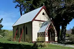 A small wooden church in a grassy environment