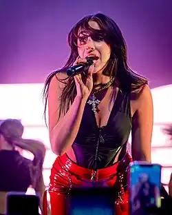 Tate McRae singing into a microphone