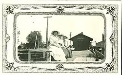 Three women sitting at the Donnellson, Iowa, train depot.