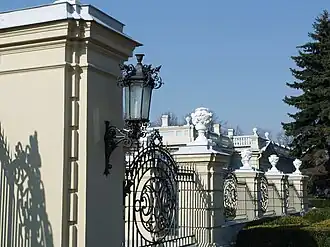 The palace is surrounded by intricate iron railings.