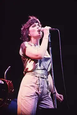 A woman is seen singing onstage.