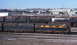 Blue and yellow locomotive in yard