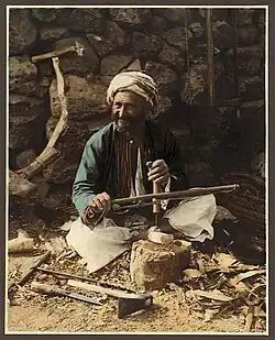 An American Colony Hand-coloured photography of a village carpenter.