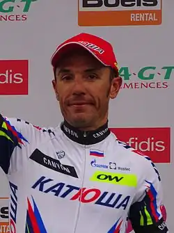 A photograph of Joaquim Rodríguez raising his arm to acknowledge applause