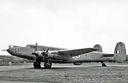 A black and white image of a four-propellered aircraft