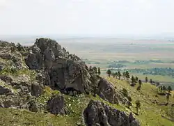 Photograph of the rocky summit of Bear Butte and the view over the Dakota plains.