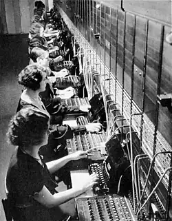 Photograph of operators at a large telephone switchboard