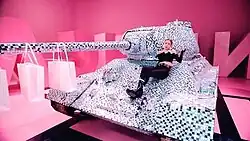 Jennie sitting atop a diamond-encrusted tank on the set of the music video
