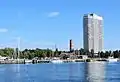 View from the Trave estuary area of the historic lighthouse and the Maritim Hotel on the promenade of Lübeck-Travemünde
