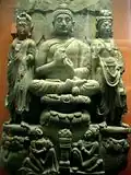 Buddha triad and kneeling Kushan devotee couple. 3rd century.