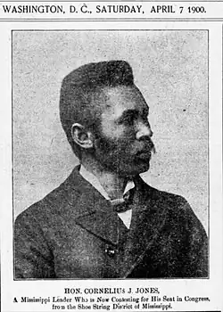 A newspaper headshot of Cornelius Jones, a black man with a handlebar moustache wearing a dark suit and posing in profile. The image is dated Washington, DC, Saturday, April 7, 1900. Its caption reads, "Hon. Cornelius J. Jones, a Mississippi lawyer who is now contesting for his seat in Congress from the Shoe String District of Mississippi."
