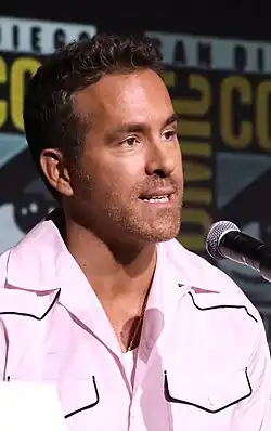 Reynolds speaking into a microphone