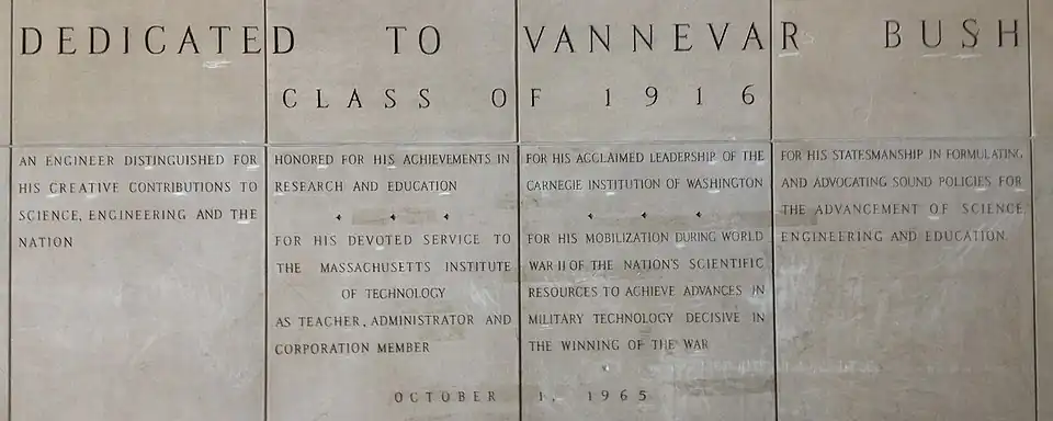 Four large panels with words carved in stone. The inscriptions reads: "Dedicated to Vannevar Bush Class of 1916. An engineer distinguished for his creative contributions to science, engineering and the nation. Honored for his achievements in research and education. For his devoted service to the Massachusetts Institute of Technology as teacher, administrator and corporation member. For his acclaimed leadership of the Carnegie Institute of Washington. For his mobilization during World War II of the nation's scientific resources to achieve advances in military technology decisive in the winning of the war. For his statesmanship in formulating and advocating sound policies for the advancement of science, engineering and education. 1 October 1965"