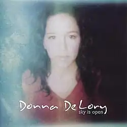 A photo of De Lory glancing towards the sun in a wilderness setting.