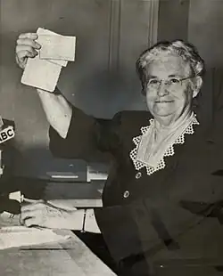 Edith holds up her Communist Party Membership Card during her testimony before the HUAC on March 28, 1953.