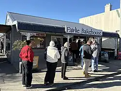A queue of people entering a bakery