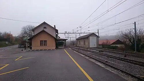 Two-story station building next to a railway line
