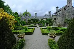 a path through a knot garden with the manor house behind it