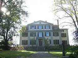 Three-storey mansion surrounded by trees and gardens