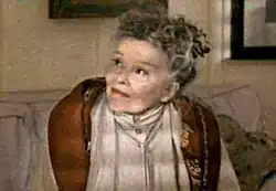 Screenshot of Hepburn, now an elderly woman, seated on a sofa