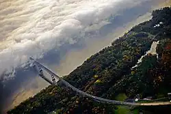 Aerial view of a bridge approaching a fog-covered river