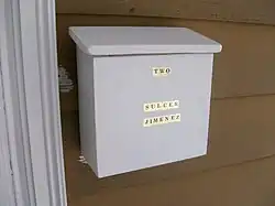 A white mailbox, attached to a wall
