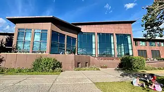 alt=Photograph of the Jackson Lake Lodge, a modern structure with many horizontal lines among the vertical trees of Grand Teton National Park.