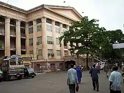 A big building in cream colour with many columns and a portico