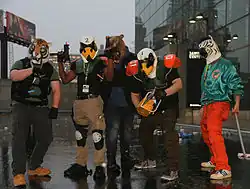 A group of people cosplaying as Hotline Miami characters, wearing a variety of animal masks, such as a tiger mask and swan masks.