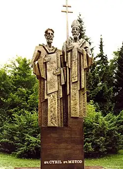 Two bearded men, one holding a book with Slavic letters, the other bearing a bishop's hat and a double-cross