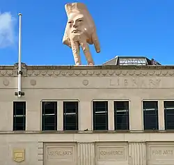 photo of giant hand sculpture on roof.