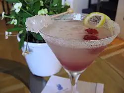 A raspberry Lemon Drop garnished with raspberry, lemon peel twist and rock candy