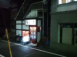 A picture of the street view a Japanese apartment at night, with light coming from the inside