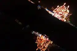 Tilted photo of the lighted temple at night, reflected in water