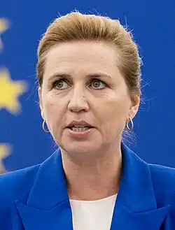 Head shot of Frederiksen with a Denmark flag in the background