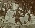 Workers setting rough stone in place, 1899.
