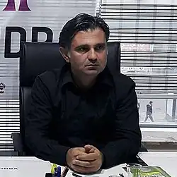 Pir at a desk with clasped hands