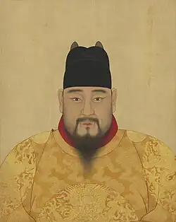 A portrait of a Chinese man wearing an yellow robe and a black cap