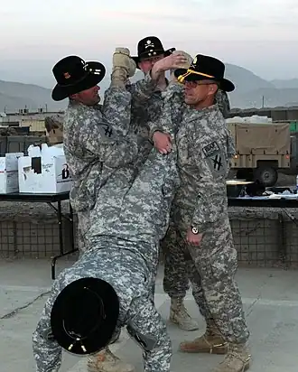 A trooper from the 1st Squadron, 108th Cavalry receives his golden spurs as part of the 'Roughriders' New Year's celebration event at FOB Torkham, Afghanistan. Golden spurs are awarded to Cavalry Troopers for service with a Cavalry unit in a combat zone.