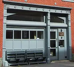 Cast-iron painted enframement with pilasters and a lintel