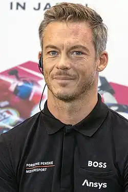 André Lotterer with an earpiece in his right rear and wearing a buttoned-up black T-shirt