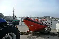 The Littlehampton Atlantic 75-class lifeboat Blue Peter 1 (B-779) being retrieved by the stations TC45 tractor in its launch cradle on the slipway outside the lifeboat station at Fishermen’s Quay on the banks of the River Arun.