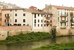 View along the Bacchiglione riverbank with old buildings lining the street.