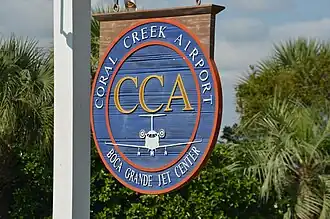 Wooden sign at the main entrance of Coral Creek Airport